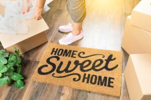 Homeowner arranging neutral furniture and clearing clutter in a bright living room.